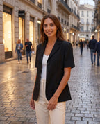 Blazer noir cintré Oriane, porté dans une rue piétonne en début de soirée