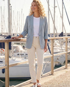Blazer d'été bleu ciel Constance, porté sur un quai de marina au soleil