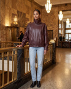 Blouson effet cuir bordeaux Octavie, porté dans un hall art déco