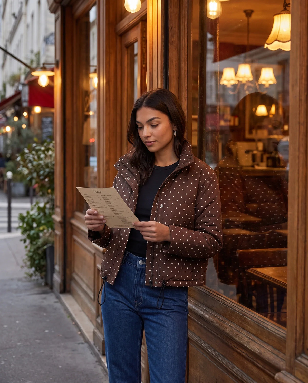Bomber court à pois chocolat Célestine, porté devant un café vintage en soirée