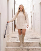 Bottes chaussettes hautes en maille Sylvette — Beige, portées dans un escalier de pierre claire d'une ruelle du sud