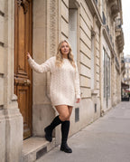 Bottes chaussettes hautes en maille Sylvette — Noir, portées sous le porche d'un immeuble en pierre de taille