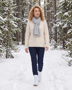 Bottes de neige fourrées à lacets Lorraine — Blanc, portées sur un sentier forestier enneigé bordé de sapins