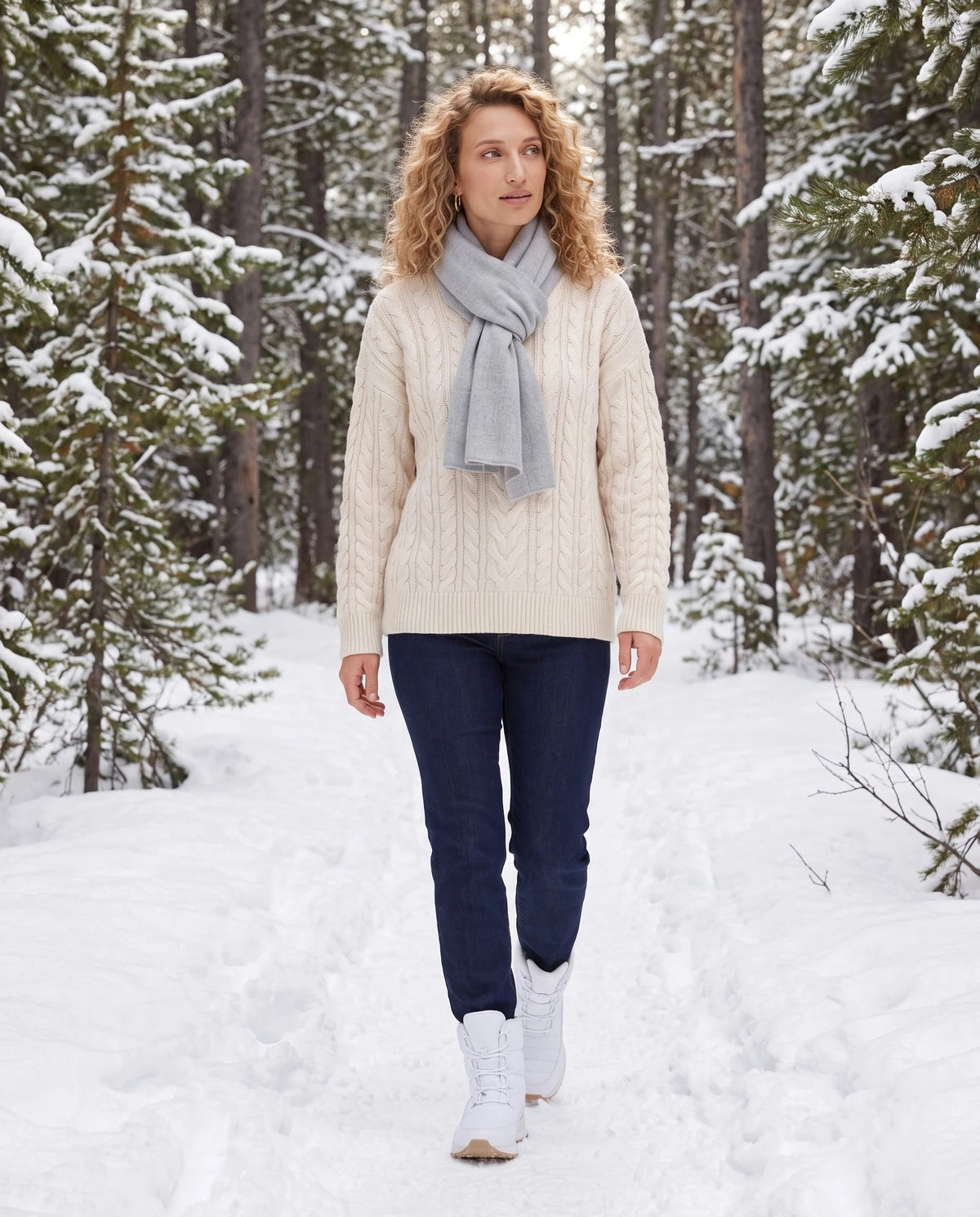 Bottes de neige fourrées à lacets Lorraine — Blanc, portées sur un sentier forestier enneigé bordé de sapins