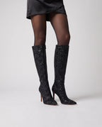 Bottes hautes à paillettes à talon aiguille Amarante — Noir, portées en plan rapproché avec des collants opaques