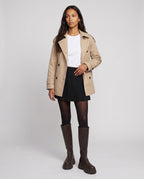 Bottes hautes à plateforme crantée Sigolène — Chocolat Foncé, portées en plein pied studio avec un trench court beige