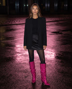 Bottes hautes slouchy à strass Odalie — Fuchsia, portées sur un asphalte mouillé sous une lueur rose