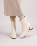 Bottines zippées en simili brillant Reine — Crème, portées en plan rapproché