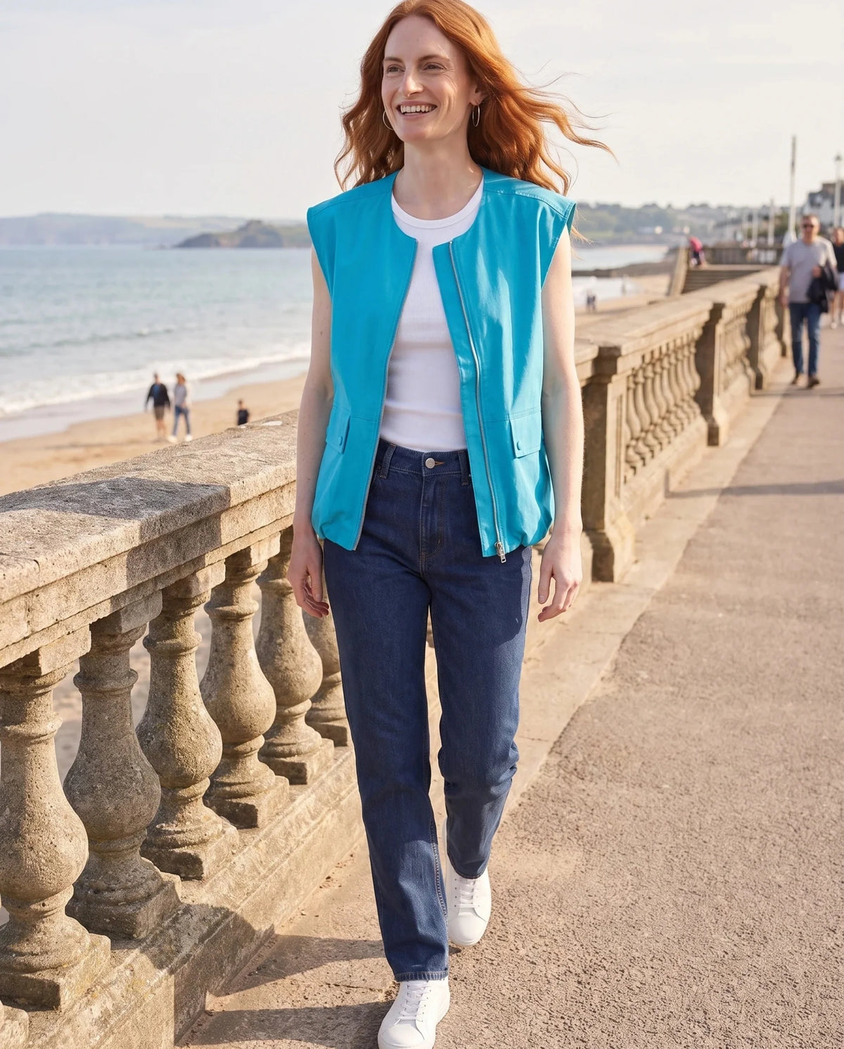 Gilet cargo zippé bleu turquoise Paloma, porté sur une promenade en front de mer