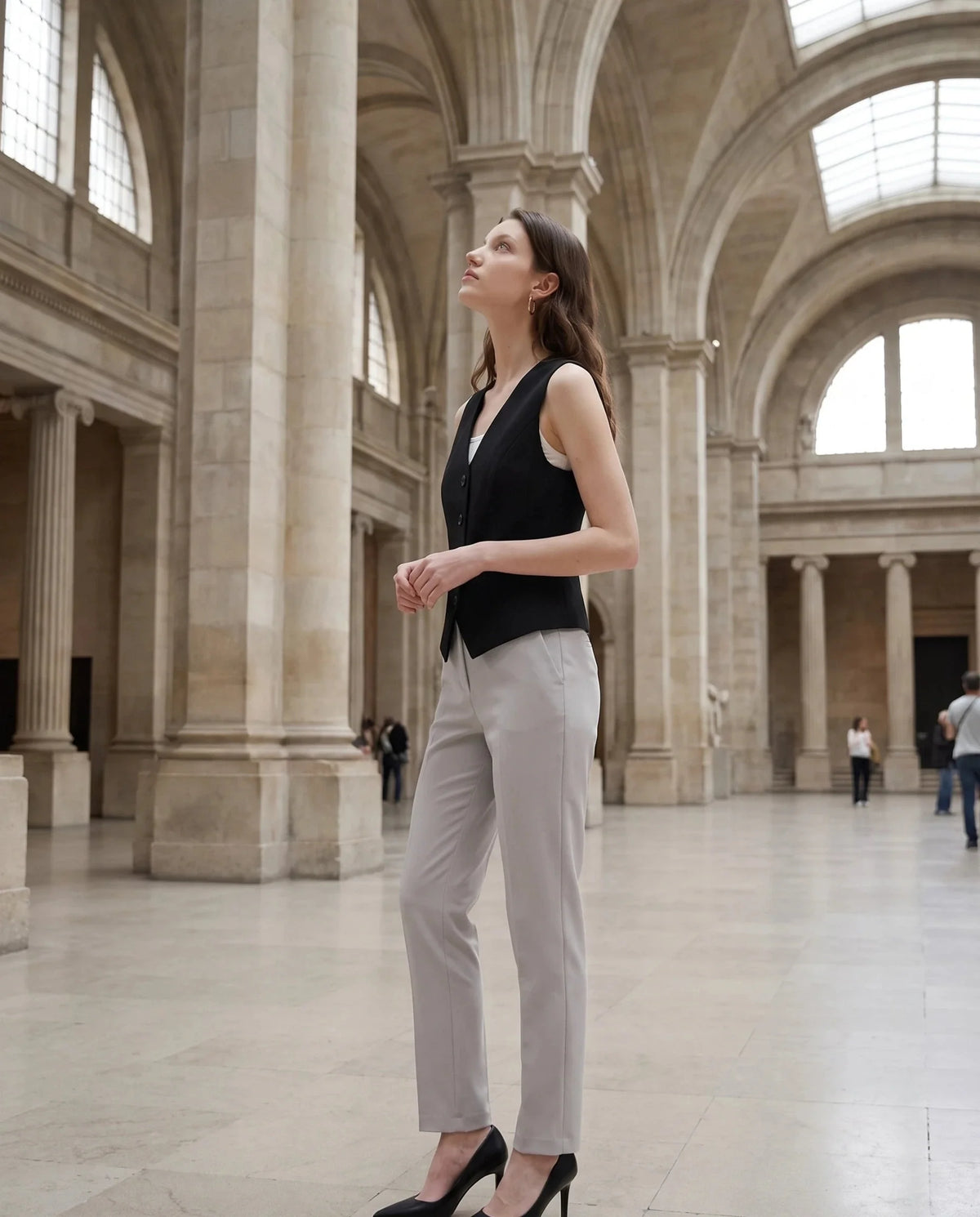 Gilet de tailleur noir Bérénice, porté dans une galerie de musée lumineuse