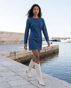 Bottes santiags hautes à talon effet cuir Anastasie — Blanc Cassé, portées sur un quai en pierre claire le matin