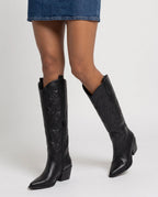 Bottes santiags hautes à talon effet cuir Anastasie — Noir, portées en plan rapproché avec une robe en jean