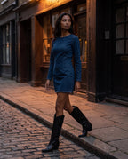 Bottes santiags hautes à talon effet cuir Anastasie — Noir, portées dans une rue pavée au crépuscule