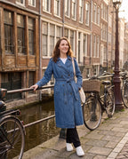Trench en jean bleu denim Théodora, porté le long d'un canal