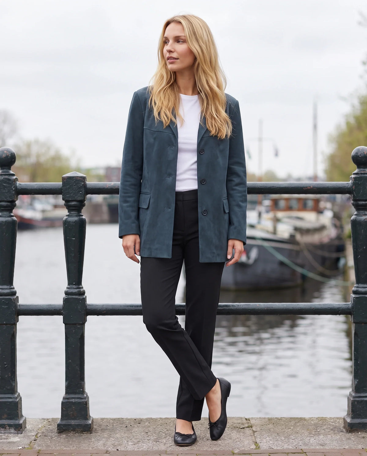 Veste-blazer en suédine bleu pétrole Eugénie, portée sur un quai de canal