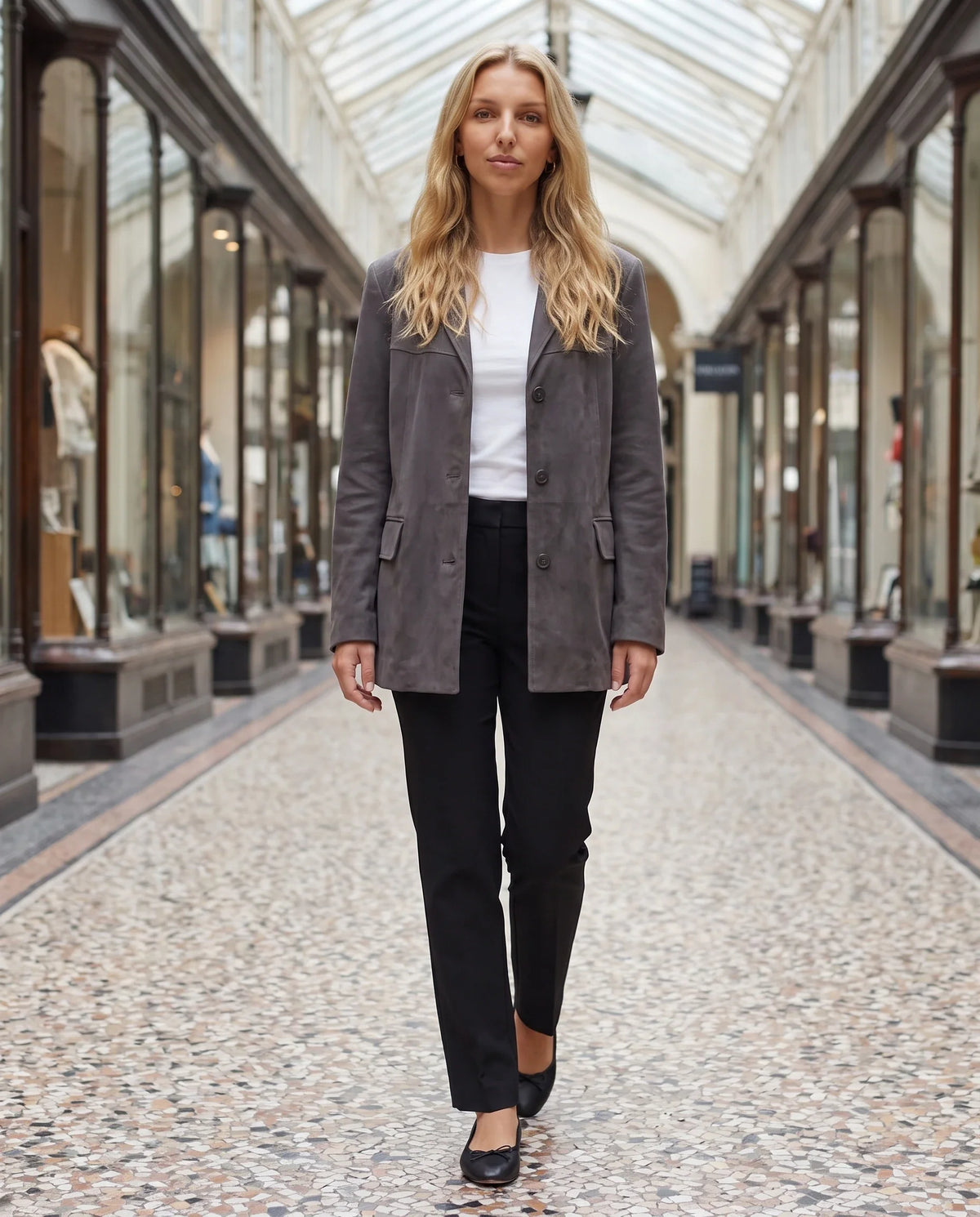 Veste-blazer en suédine gris anthracite Eugénie, portée dans un passage couvert