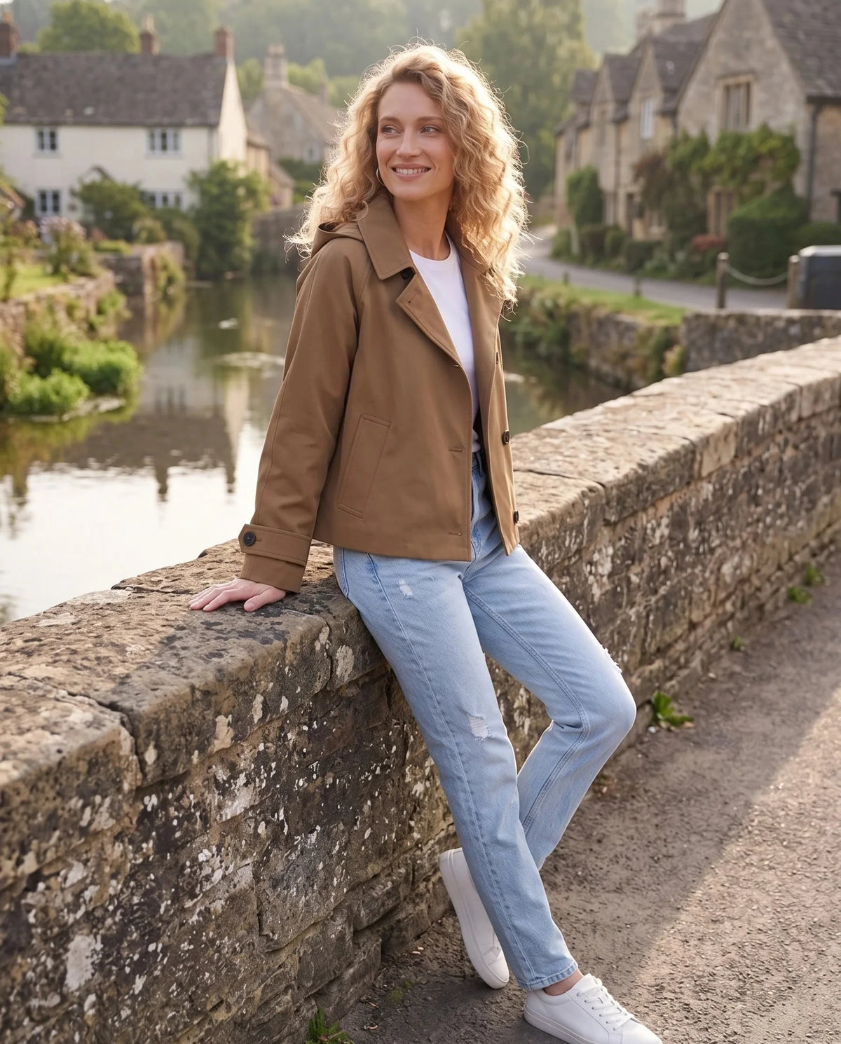 Veste à capuche brun Eulalie, portée sur un pont de village en pierre