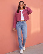 Veste courte Y2K rose framboise Sidonie, portée devant un mur corail