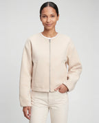 Veste zippée sans col en maille crème Capucine, plan rapproché en studio