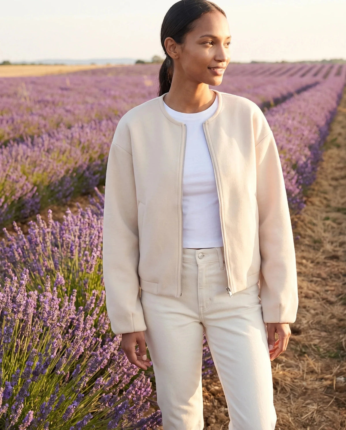 Veste zippée sans col crème Capucine, portée au bord d'un champ de lavande