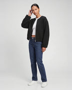 Veste zippée sans col en maille noire Capucine, vue de trois quarts en studio