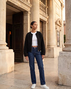 Veste zippée sans col noire Capucine, portée sur le parvis d'un théâtre ancien