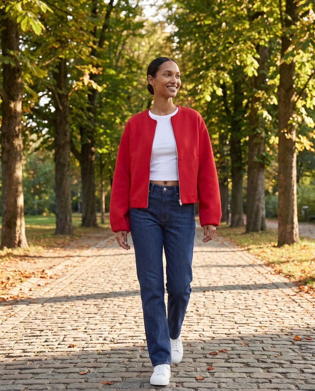 Veste zippée sans col rouge Capucine, portée dans une allée de marronniers